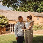 Couple smiling outside rustic brick house