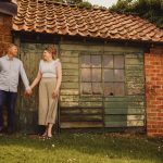 Couple holding hands by rustic shed