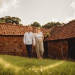 Couple walking by rustic barn in countryside