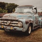 Vintage blue Ford truck on grass field