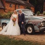 Bride and groom beside vintage truck