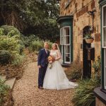 Bride and groom outside rustic stone house