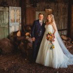 Bride and groom in rustic barn setting.