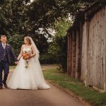 Bride and groom walking on a garden path.