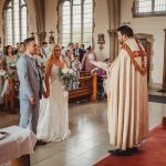 Bride and groom at altar in church ceremony.