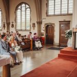 Wedding ceremony in a church with guests seated.