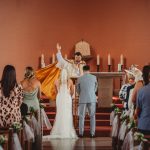 Wedding ceremony in church with priest and couple.