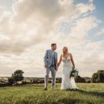 Wedding couple smiling in a picturesque field.