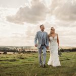 Couple walking in countryside on wedding day.