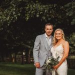 Couple posing outdoors in wedding attire