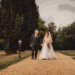 Bride and groom walking in garden pathway