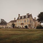 Historic stone manor house on foggy day