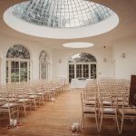 Elegant wedding venue with chairs and welcome sign.