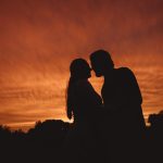 Silhouette of couple kissing at sunset