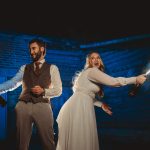 Bride and groom spraying champagne playfully.