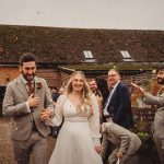 Bride and groom walking through confetti outside reception.