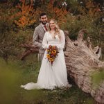 Bride and groom in autumnal woodland wedding photo.