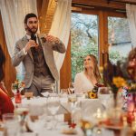 Groom giving speech at wedding reception.