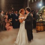 Bride and groom dancing at rustic wedding reception.