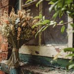 Rustic dried flower bouquet by weathered window.