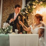 Bride and groom toasting at wedding reception.