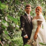 Bride and groom in garden setting.