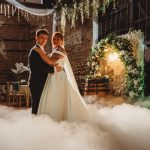 Bride and groom dancing at a rustic wedding venue.