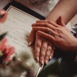 Marriage certificate with hands and rings together.