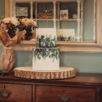 Elegant white and green wedding cake on dresser.