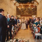 Bride walking down aisle at wedding ceremony.