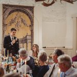 Wedding speech at reception with guests listening.