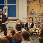 Wedding speech laughter at reception with guests.