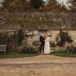 Couple in front of rustic countryside cottage.