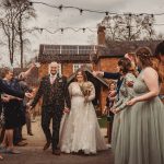 Bride and groom exiting amidst confetti celebration