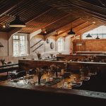 Rustic dining room setting with wooden beams and tables.