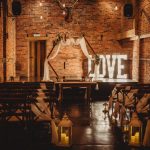 Rustic wedding venue with illuminated 'LOVE' sign.