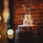 Rustic wedding cake on wooden barrel.