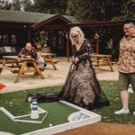 People playing mini-golf at outdoor event venue.