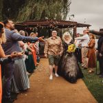 Wedding couple walking through flower petals