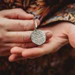 Person holding engraved keychain gift in hands.