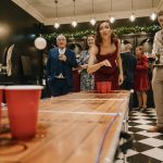 Group playing beer pong at festive gathering.