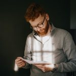 Man reading a letter with sunlight streaming in.