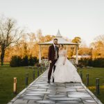 Couple standing on garden path before gazebo