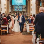 Bride and groom exiting church after wedding ceremony.