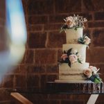 Three-tier wedding cake with floral decorations.