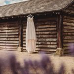 Wedding dress hanging on rustic wooden barn