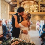 Bride and groom kissing during wedding ceremony.