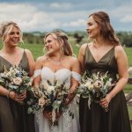 Bride with bridesmaids holding bouquets outdoors