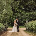 Bride and groom in lush garden path