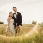 Bride and groom in a sunny field wedding